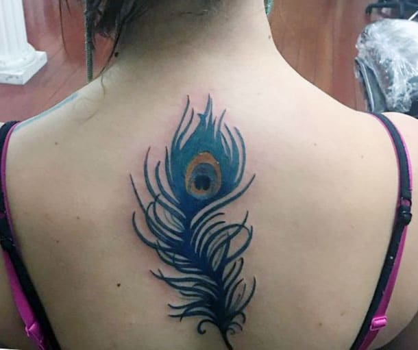 Feather tattoo on the back with a blue ink design brings the captivating look