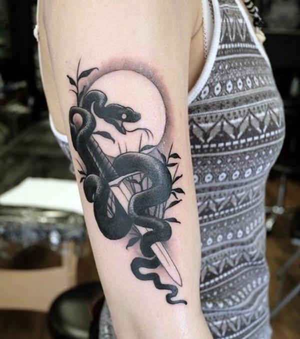 Snake tattoo with black ink on the arm promotes a flashy look in ladies