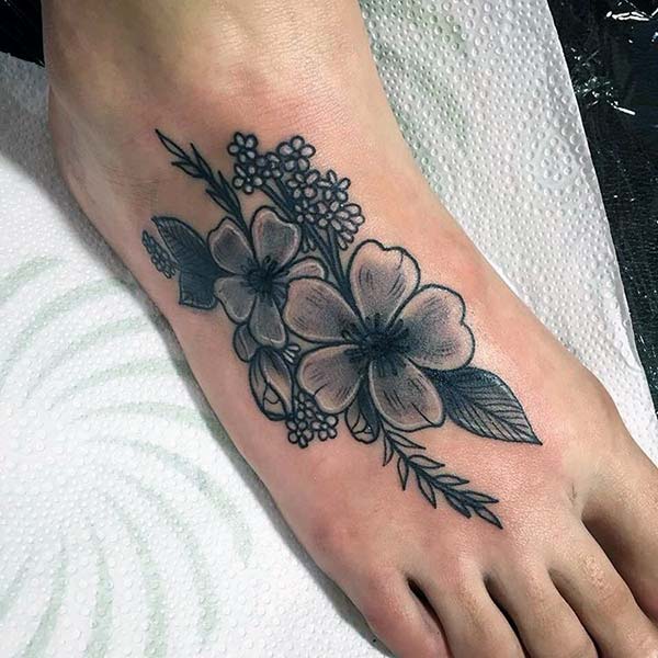 Foot Tattoo for girls with a black flower design make them look ornate