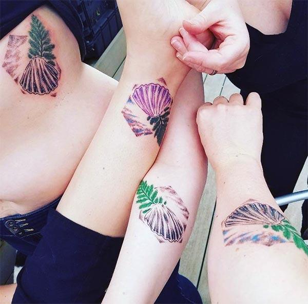 Friendship tattoo with a pink and green ink flower design make friends look attractive
