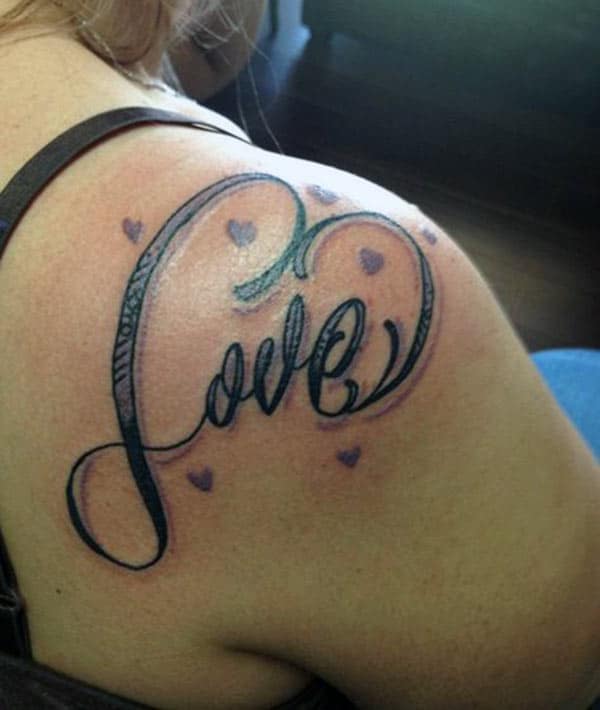 Love tattoo on the shoulder makes a woman look captivating
