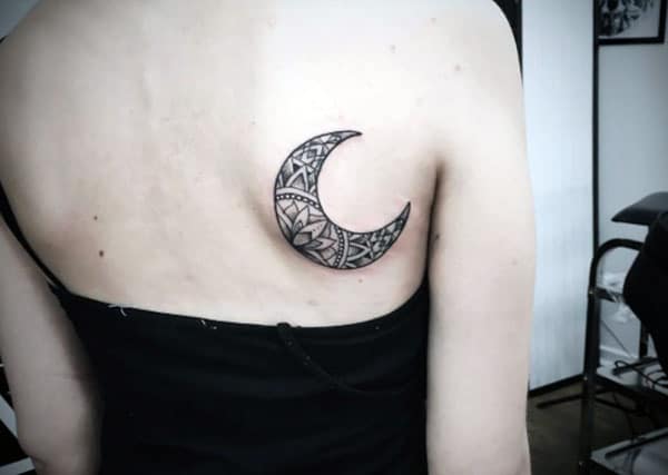 Moon tattoo on the back makes a lady appear stunning
