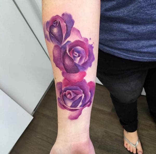 Purple ink design of the Rose Tattoo on the lower arm of women make them look attractive