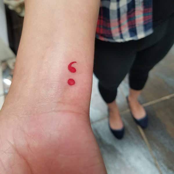 Semicolon tattoo on the lower arm makes a women look attractive