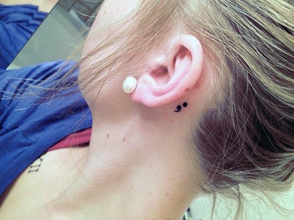 Semicolon tattoo behind the ear brings the feminist look