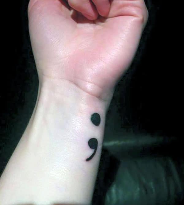 Semicolon tattoo on the wrist makes a lady look exquisite