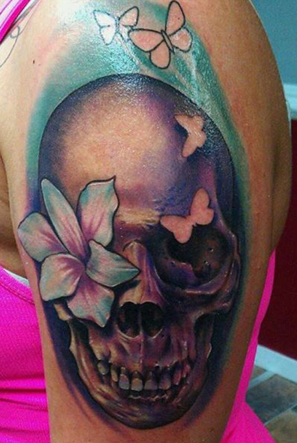 Skull Tattoo at the shoulder with a brown ink design makes a girl look attractive