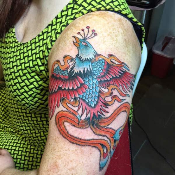 The Phoenix tattoo on the shoulder with a pink and blue ink design, make girls have splendid look
