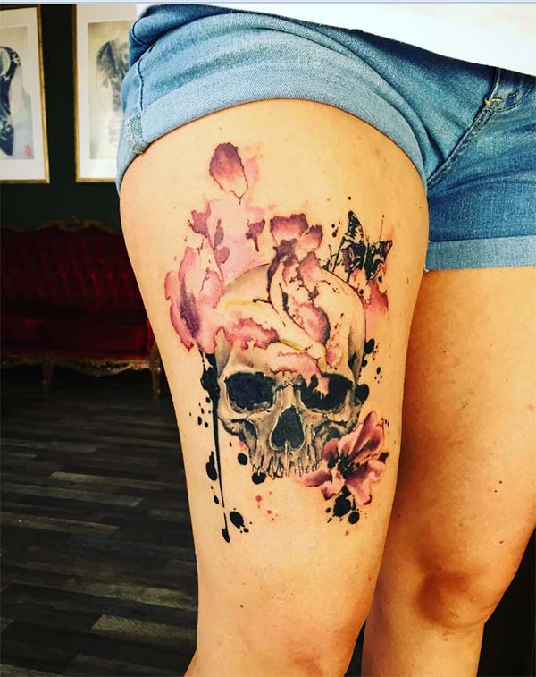 Trash polka flowers covered skull tattoo on thigh for adventurous women