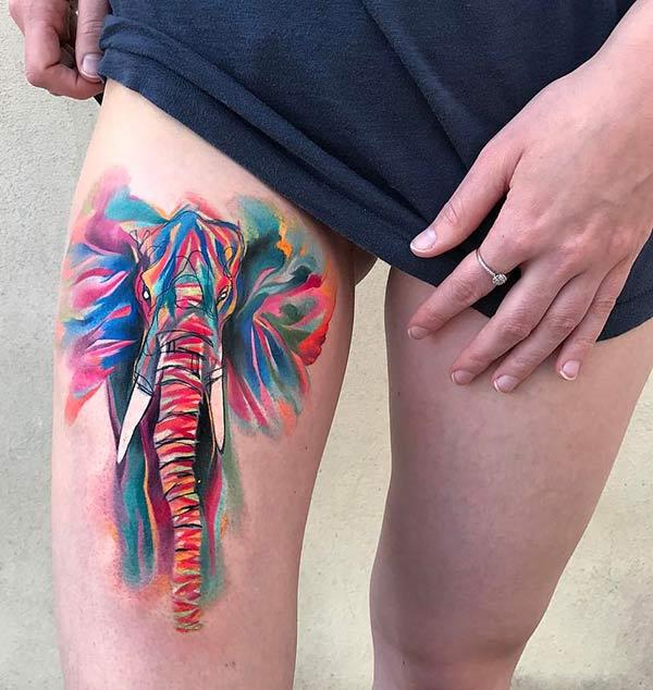 Striking bright colored elephant watercolor tattoo on thighs for wild loving Females