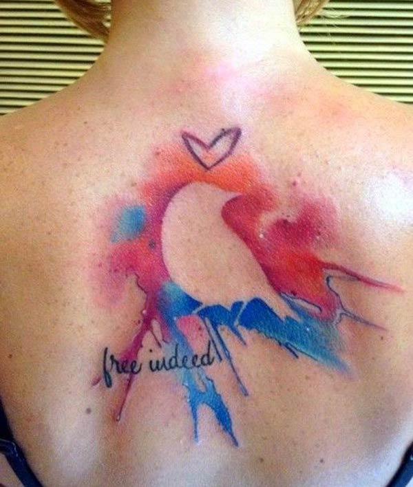 Heart bird free indeed wording watercolor tattoo on back for women