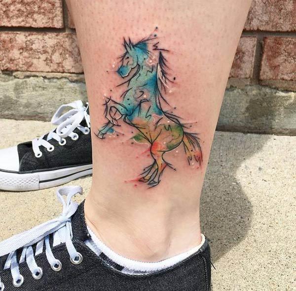 Stardust vibrant jumping horse watercolor tattoo on legs for Women