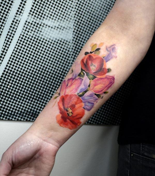 Vibrant floral water color ink forearm tattoo ideas for men flower lovers