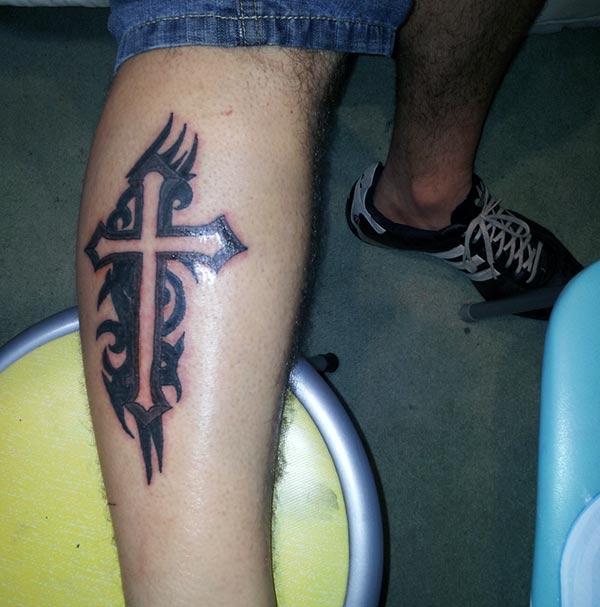 Captivating black lined tribal cross tattoo design on calf for Men
