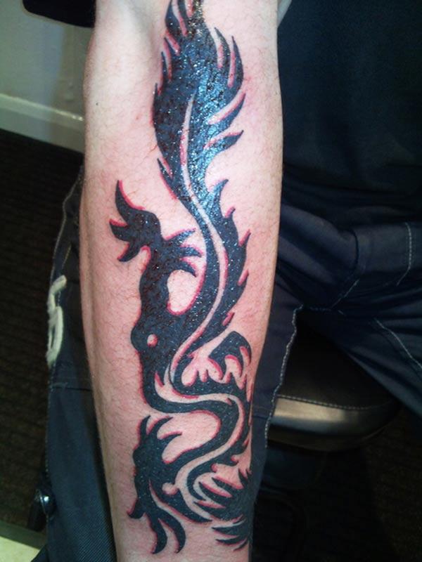 Flamboyant black and red tribal dragon tattoo ideas on Arm for Guys