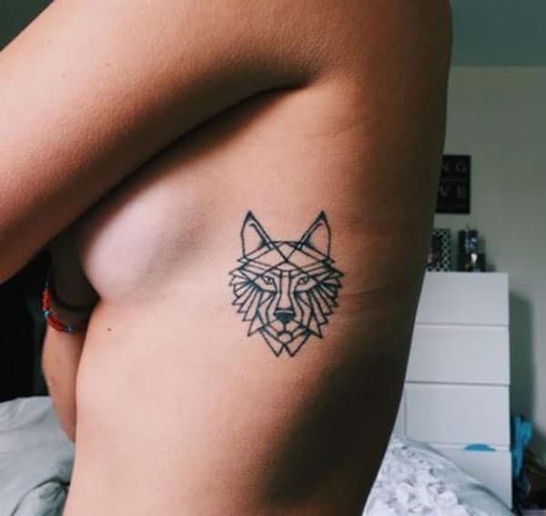 Bewitching geometric wolf face tribal tattoo design on side for fashionable girls