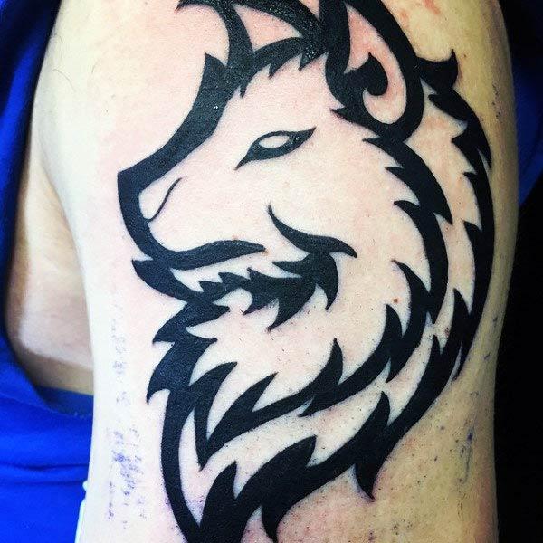 Striking tribal wolf head tattoo design on arm for stylish Men