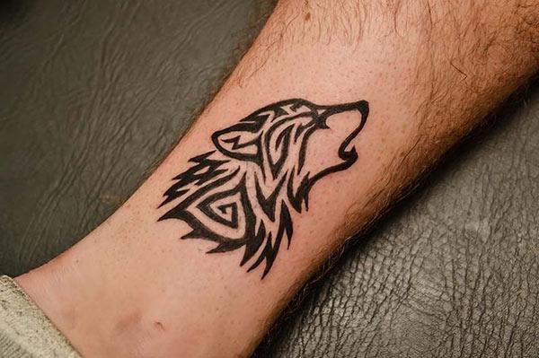 Beautiful tribal howling wolf head tattoo designs on leg for Men