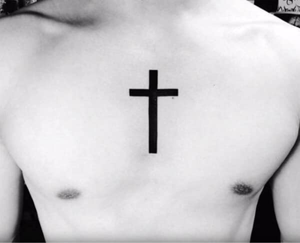 Striking broad black cross tattoo design on chest for guys