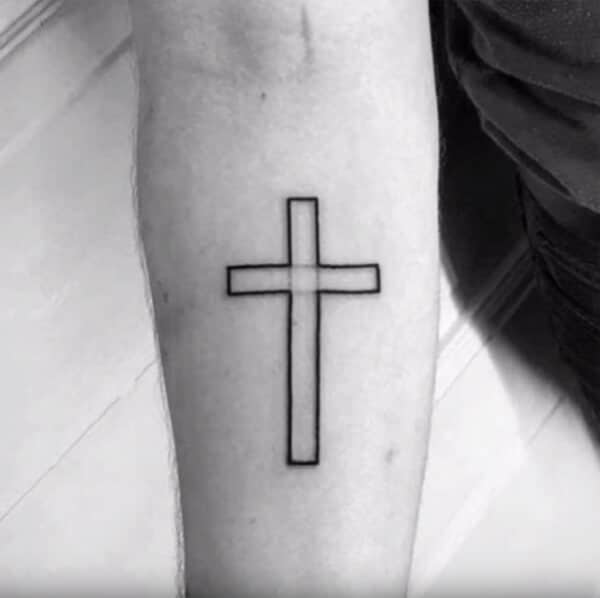 An awe-inspiring black outlined cross tattoo ideas on forearm for Boys and men
