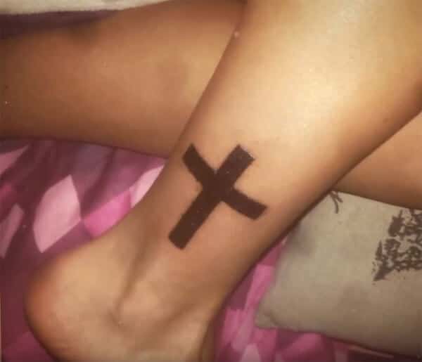 Broad black simple cross tattoo design on ankle for girls