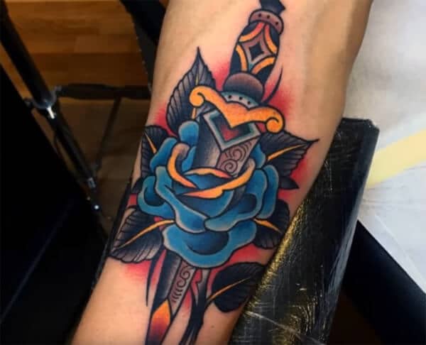 Arresting blue rose with knife tattoo ideas on forearm for Men