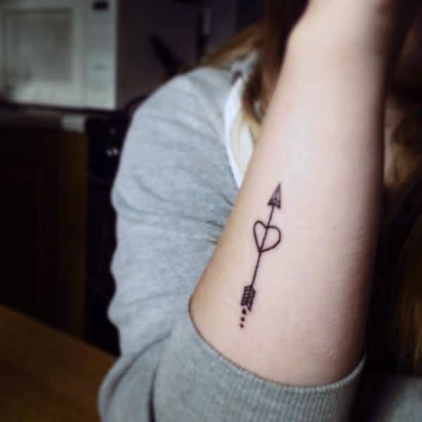 pretty arrow with heart tattoo designs on forearm for girls 