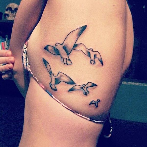 pleasant bird tattoo design on side rib for girls and women