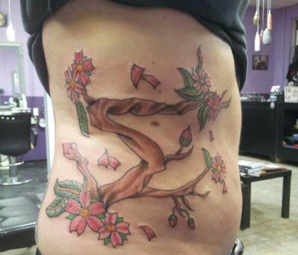 striking cherry blossom tattoo design on side rib for girls