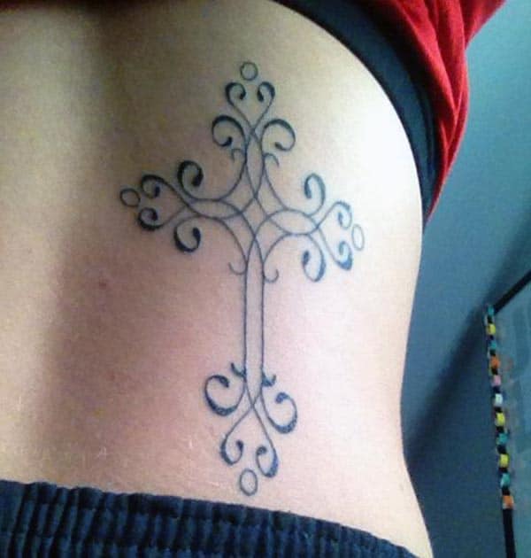 Swirly patterned cross tattoo ideas on back for girls and women