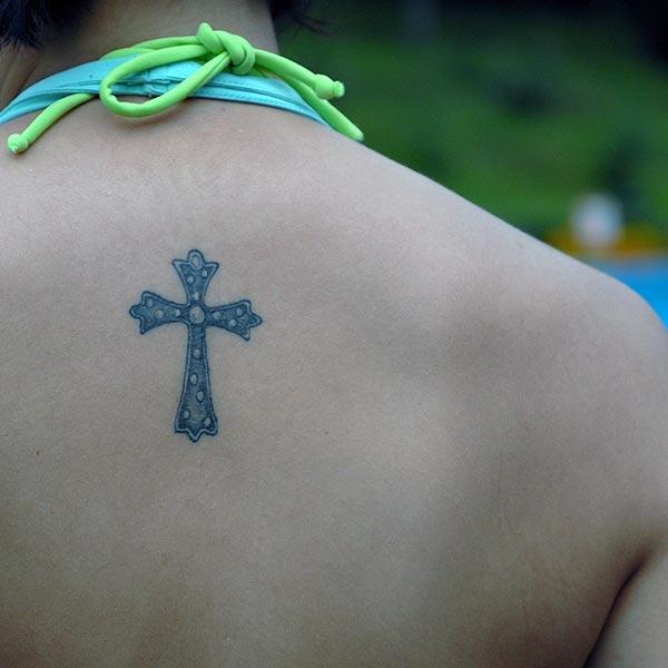 A cool tiny cross tattoo ideas for women on back