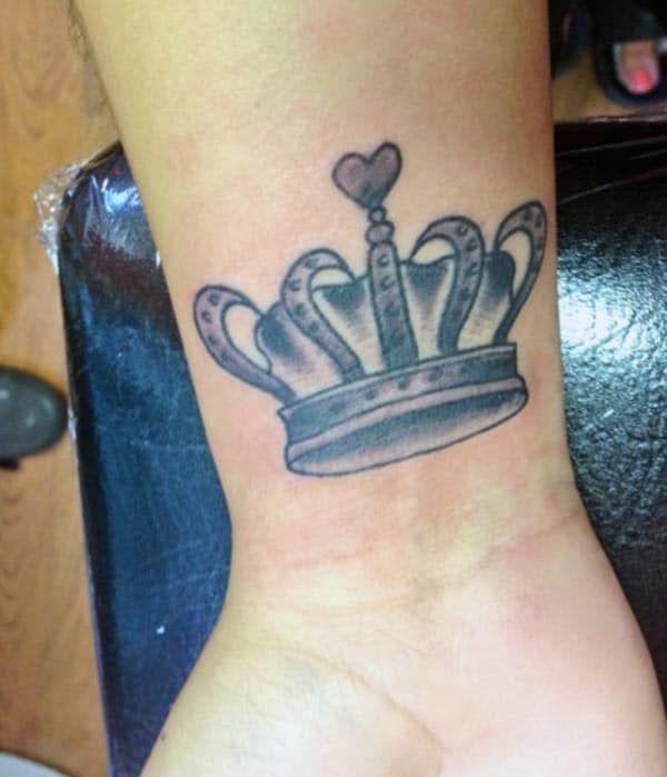 A beautiful dark and light shaded crown tattoo design on wrist for girls