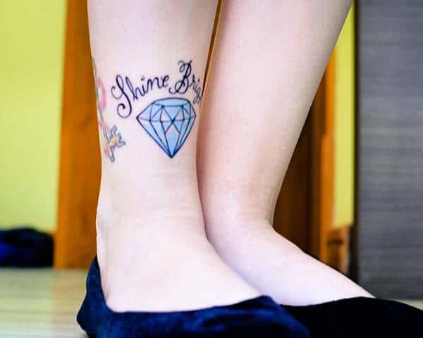 A cute tattoo of blue diamond with Shine Bright wordings on leg for Girls and Women