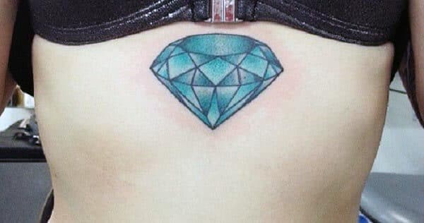 Amazing green diamond tattoo design on below chest region for Women