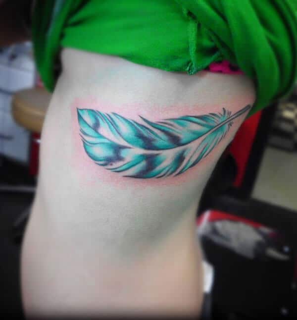 A dreamy feather tattoo design on side rib for Girls and women