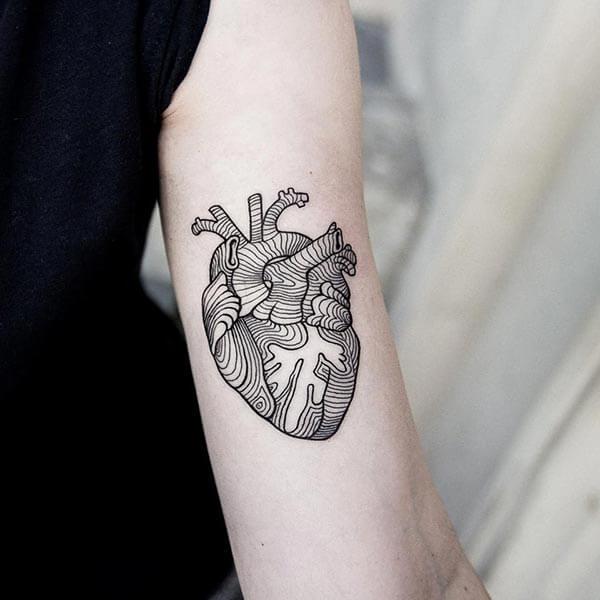 A hypnotic heart tattoo design on forearm for girls and women