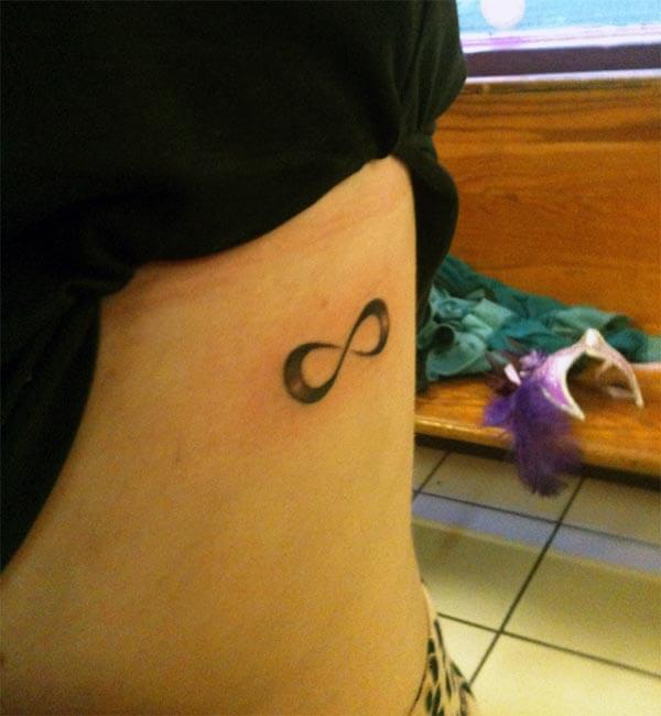 A beautiful infinity tattoo design on side rib for women