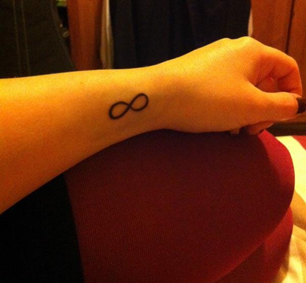 A pretty infinity tattoo design on wrist for girls