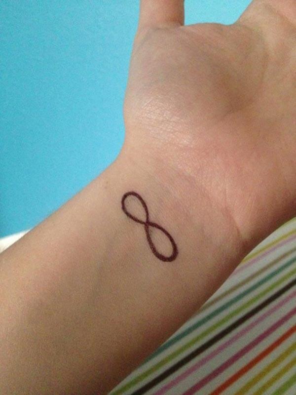 A motivating infinity tattoo design on wrist for ladies