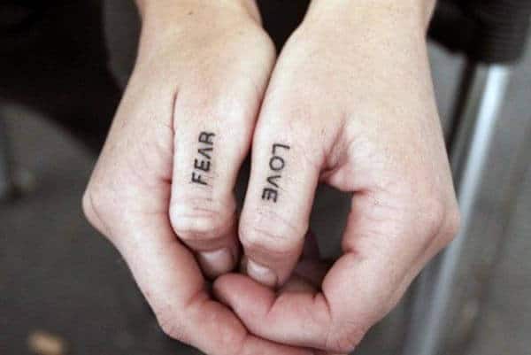 A bold love tattoo design on thumb for Ladies