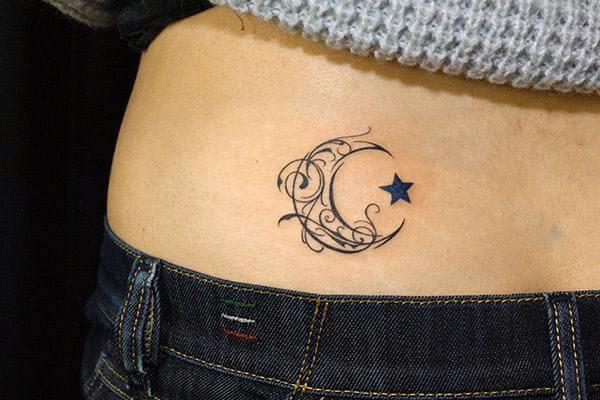 A cute little moon tattoo design on lower back for Ladies