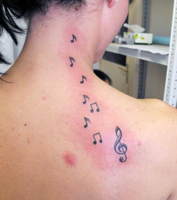 A lovely music tattoo design on back for Women