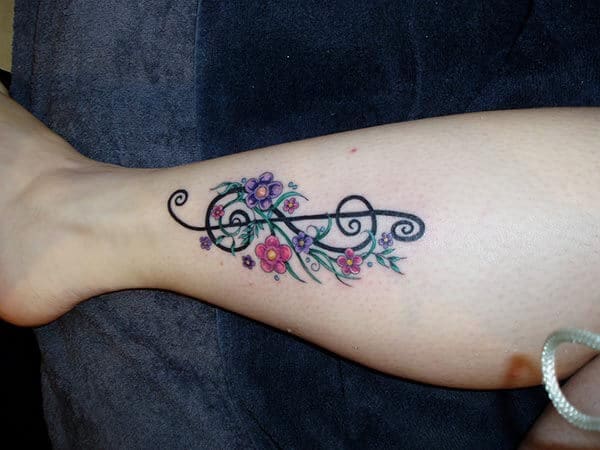 A floral music tattoo design on leg for Women