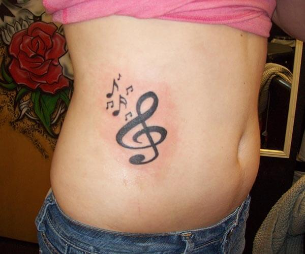 A bold music tattoo design on side belly for Ladies
