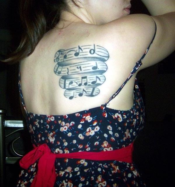 A catchy music tattoo design on back shoulder for women