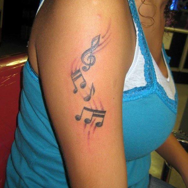 A heartwarming music tattoo design on arm for ladies