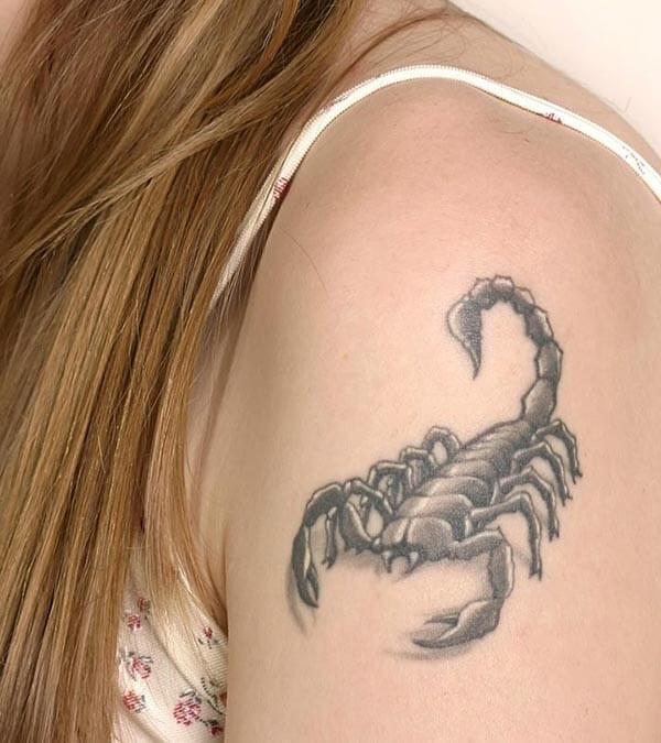 A prepossessing scorpion tattoo design on upper arm for women