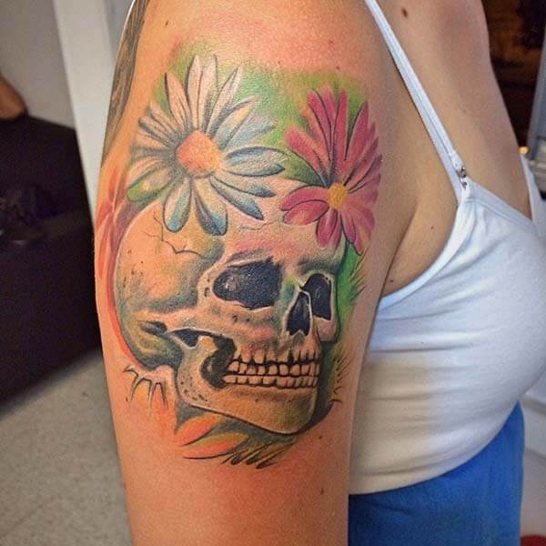 An amazing skull tattoo design on upper arm for women