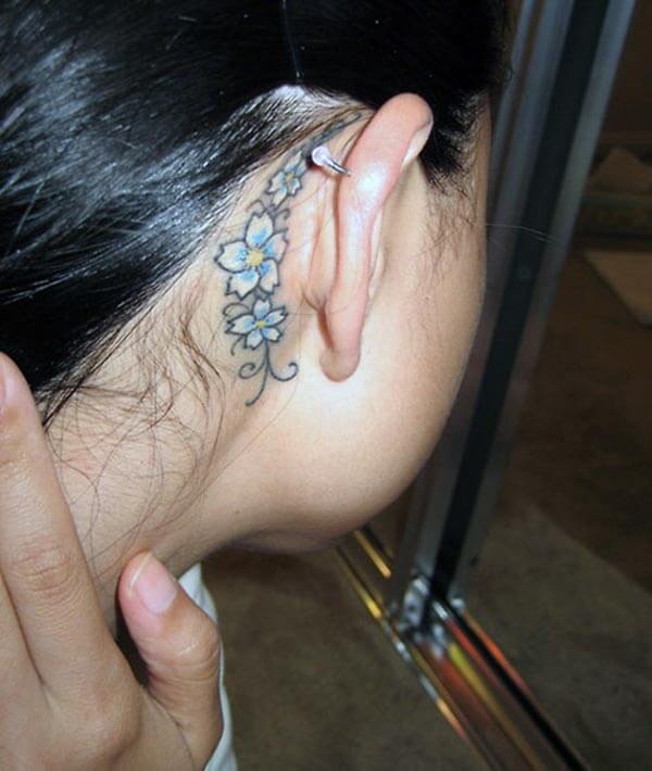 A floral behind the ear tattoo design for girls