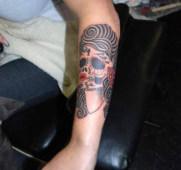 A funky day of the dead tattoo design on forearm for girls